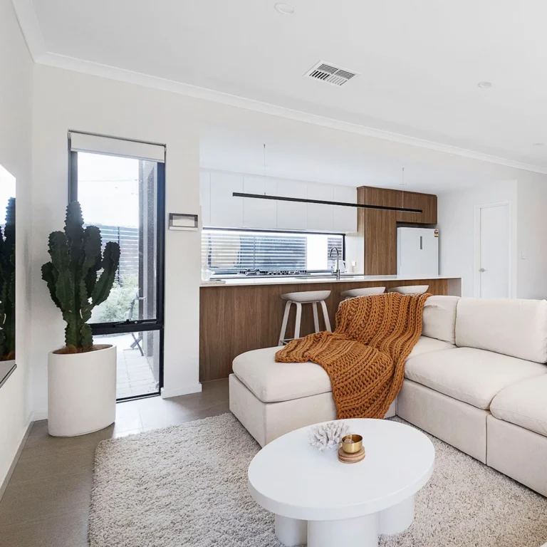 The image showcases a cozy, stylishly decorated living space with warm lighting, plush cushions, and inviting textures—perfect for attracting short-term rental guests. It highlights the importance of professional Airbnb styling and property management, ensuring your Perth home stays guest-ready, maximises bookings, and generates income while you’re on holiday.